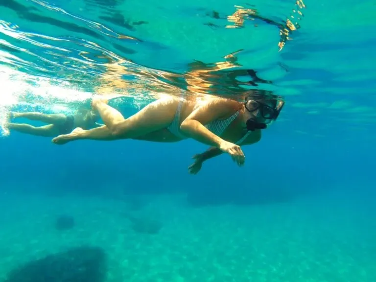 Woman snorkelling just below the surface of turquoise water