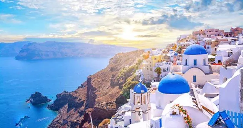 Blue-domed churches and white houses on the cliffs of Santorini above the caldera