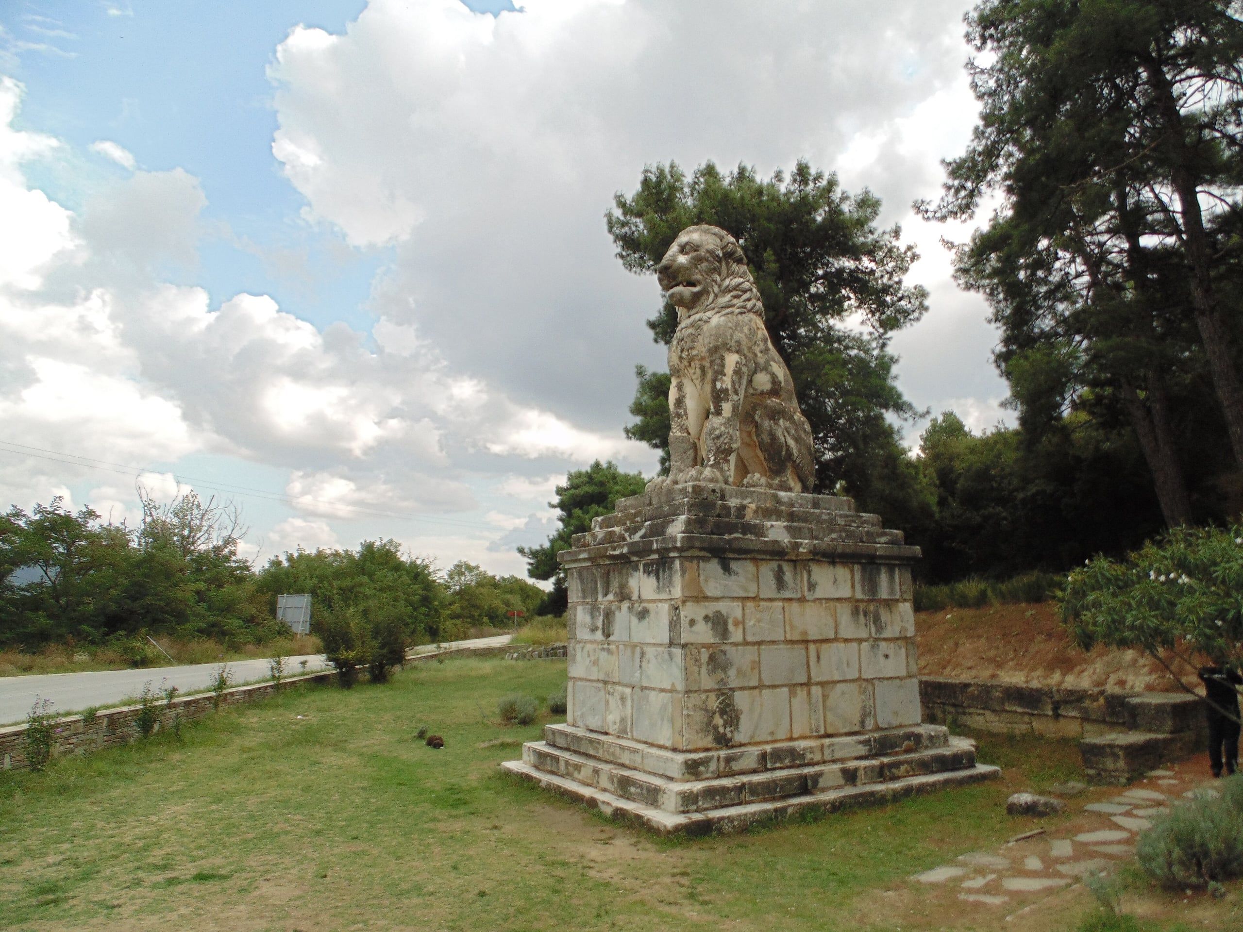 The marble Lion of Amphipolis on its tall base under a cloudy sky