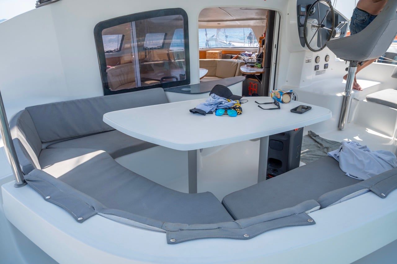 Shaded cockpit table and cushioned seats on a catamaran