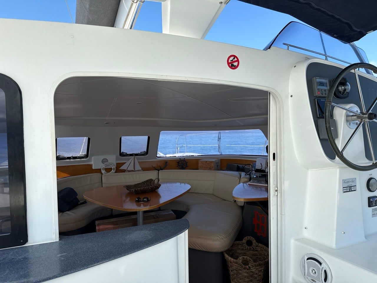 Catamaran helm station beside the open door to the saloon
