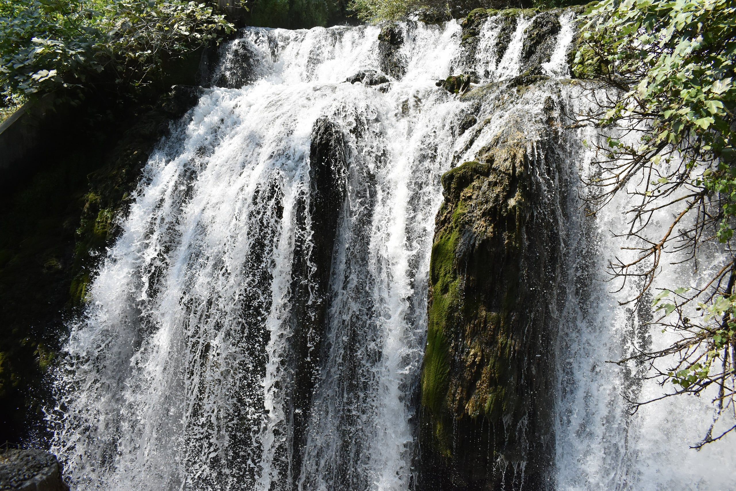 White water cascading down mossy rocks at the Edessa waterfalls park