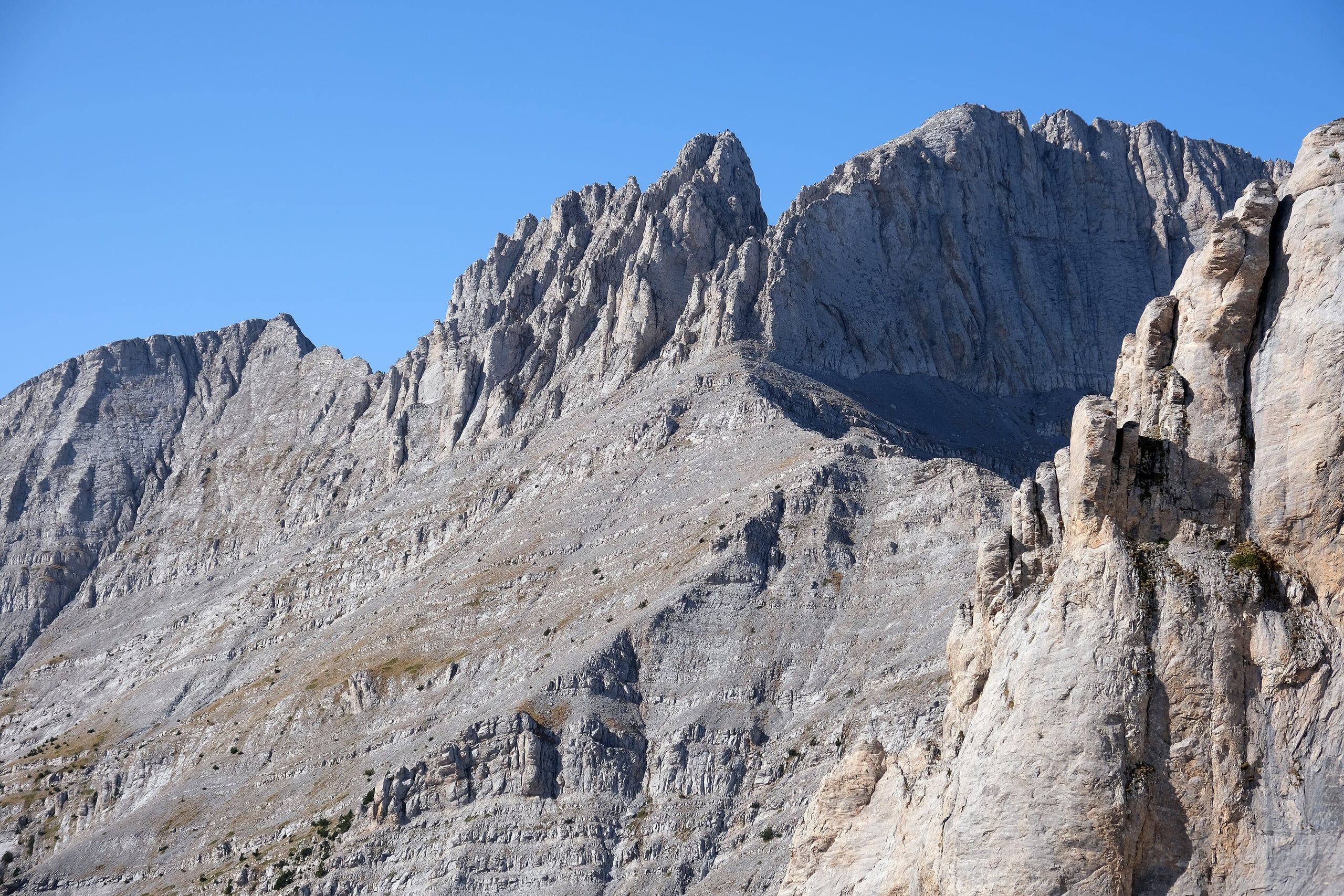 Sheer grey limestone ridges and peaks of Mount Olympus in bright sunshine