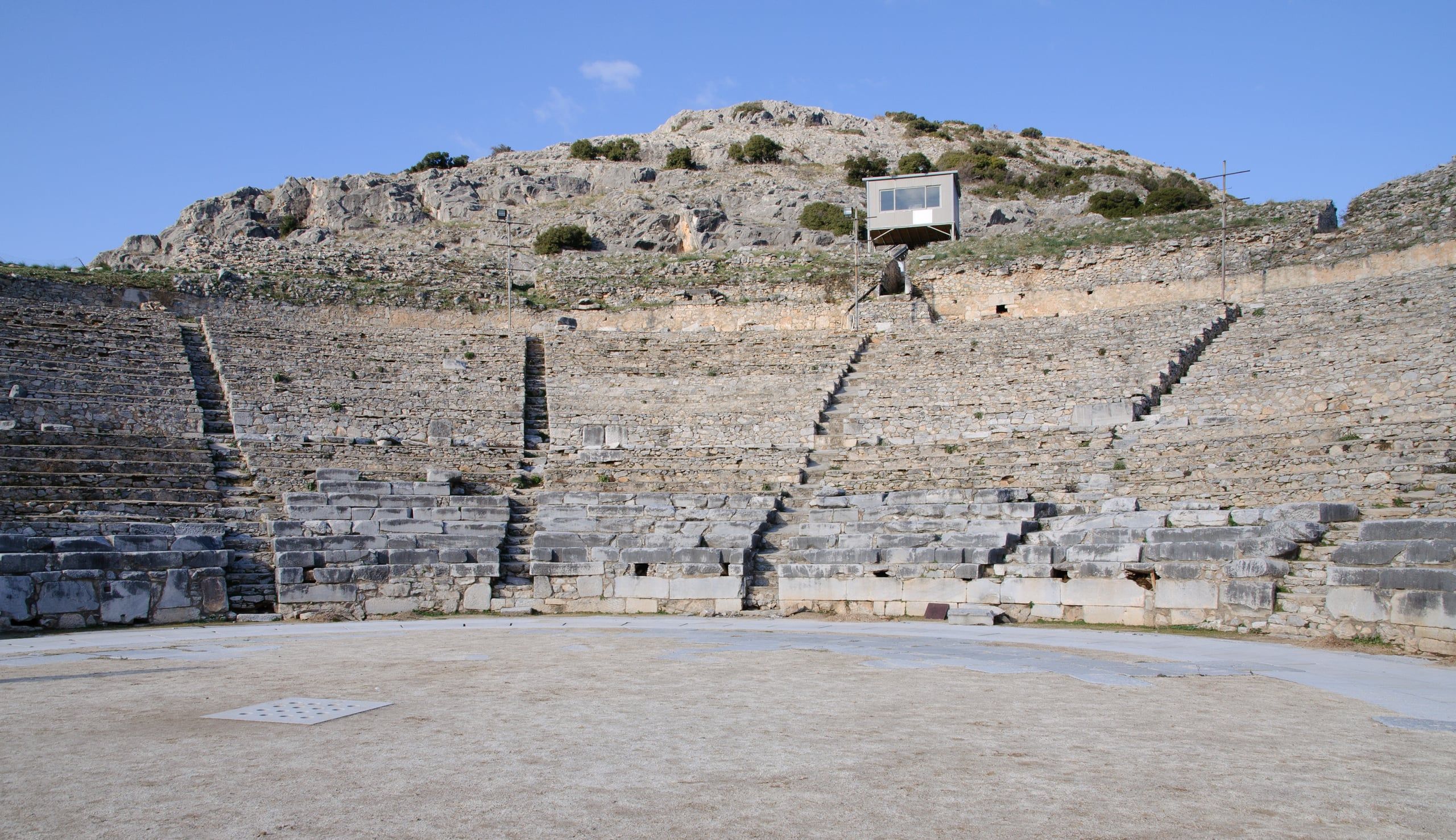 Stone seating of the ancient theatre of Philippi below the acropolis hill